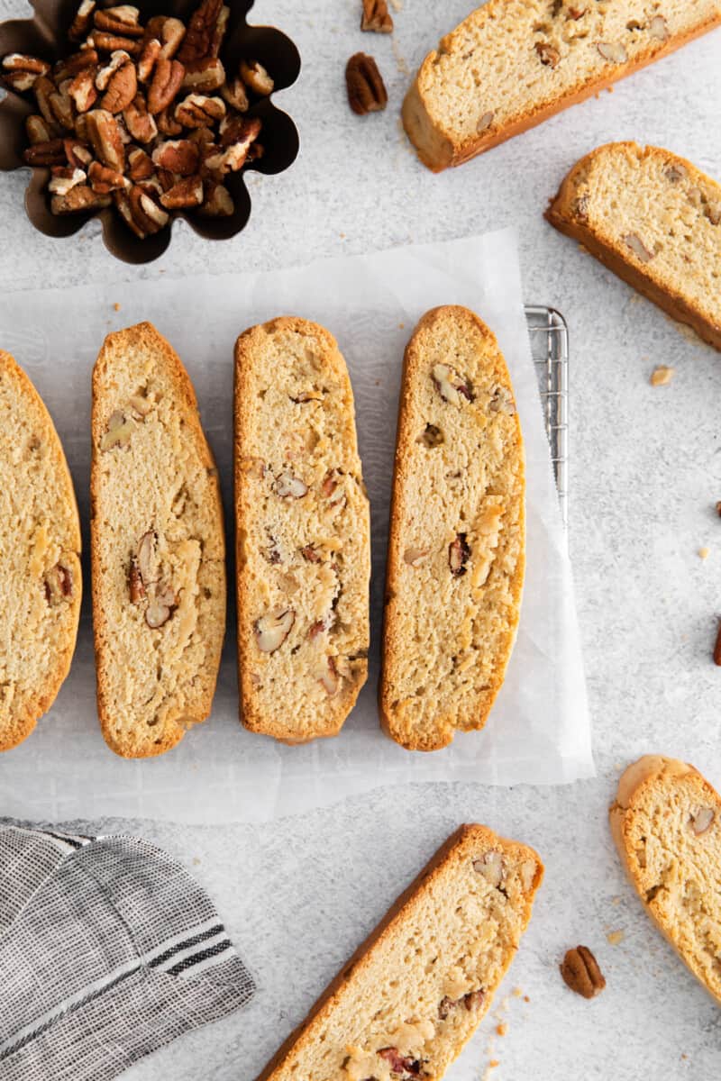 4 maple pecan biscotti on a parchment lined wire rack.