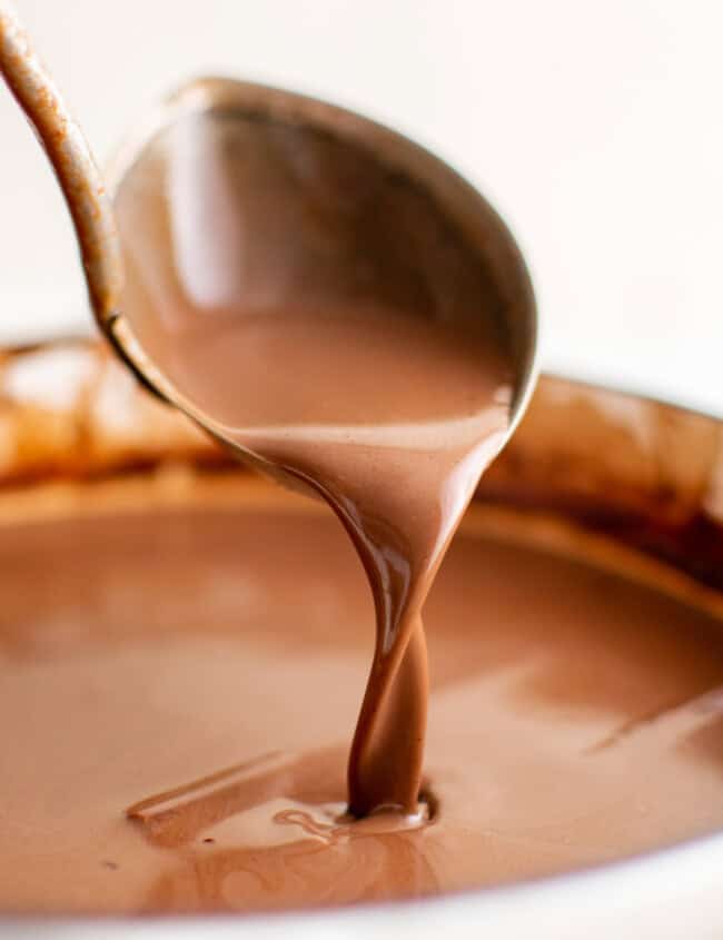 a spoon pouring mexican hot chocolate into a cup.