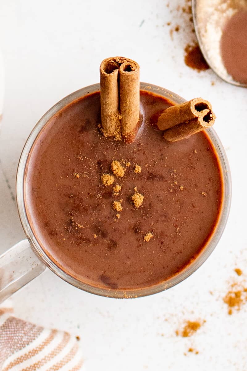 overhead view of a mug of mexican hot chocolate with a cinnamon stick.
