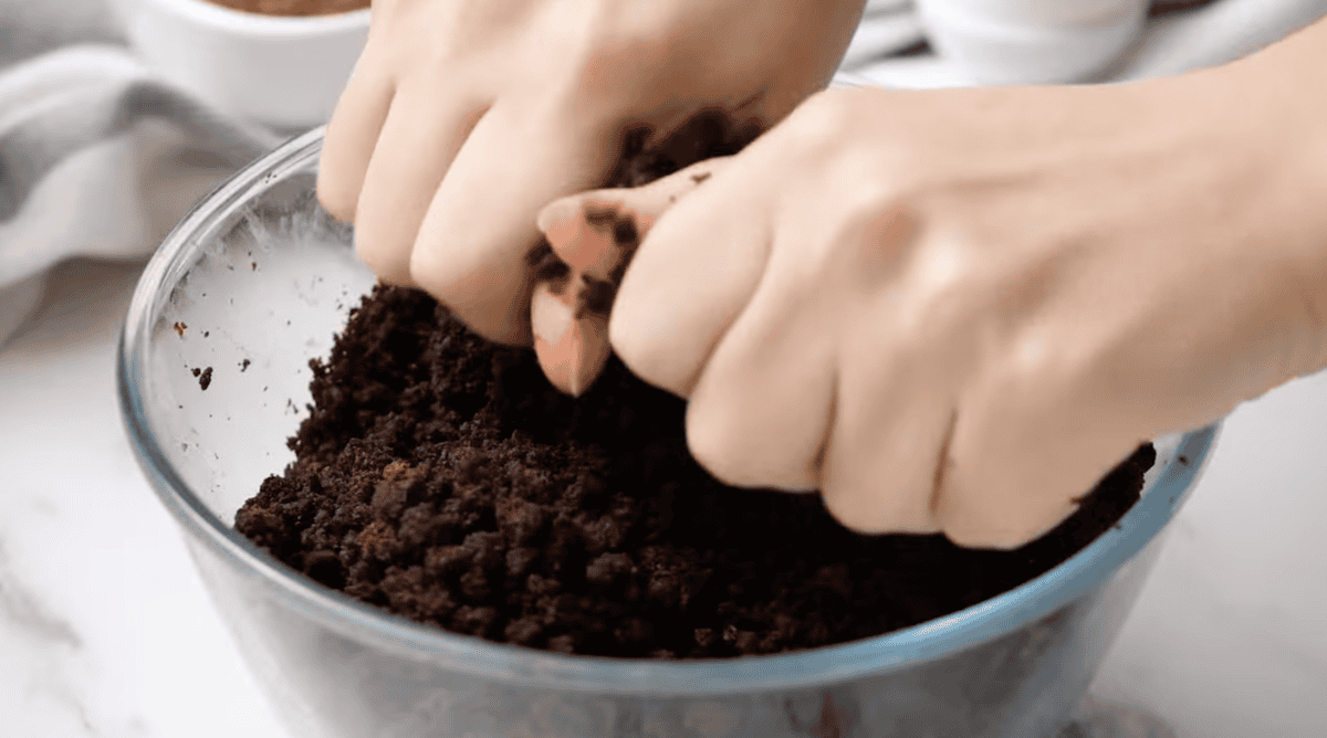 crumbling chocolate cake scraps in a glass bowl.