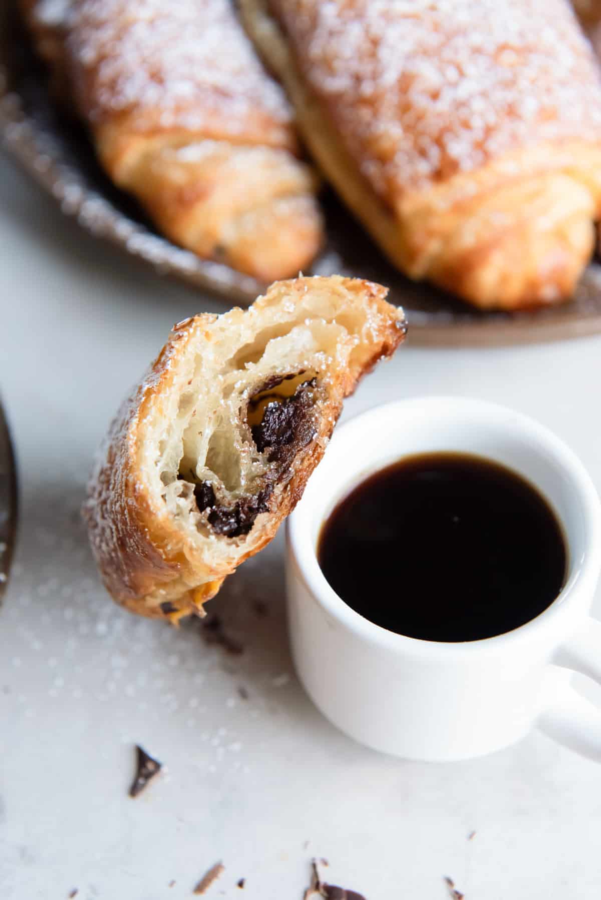 a chocolate croissant with a cup of coffee