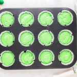 cupcake tin filled with green cupcake batter