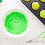 a bowl of neon green dyed frosting