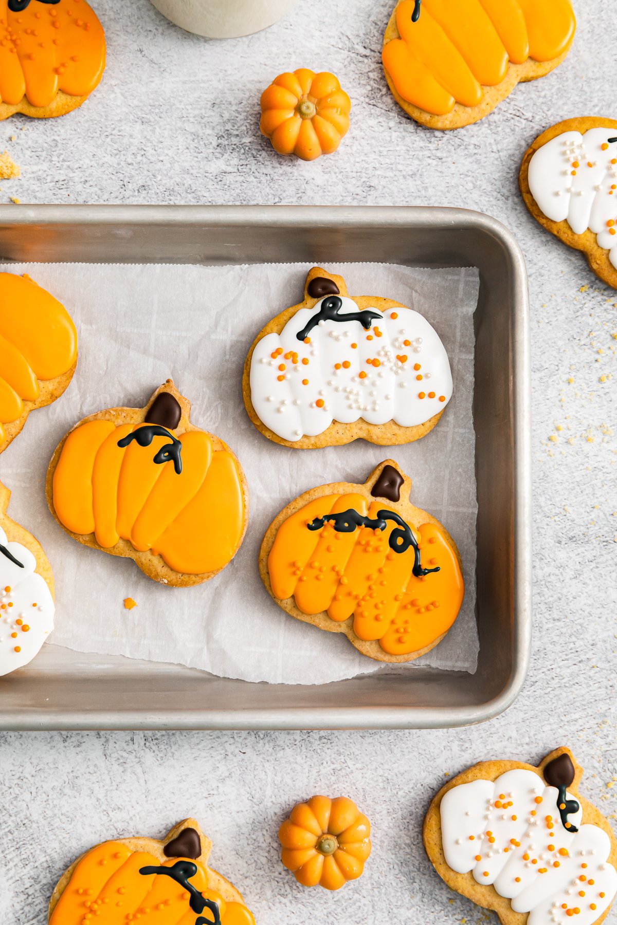 pumpkin sugar cookies, some with orange frosting, some with white frosting