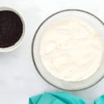 buttercream frosting in a bowl next to a bowl of crushed oreos.