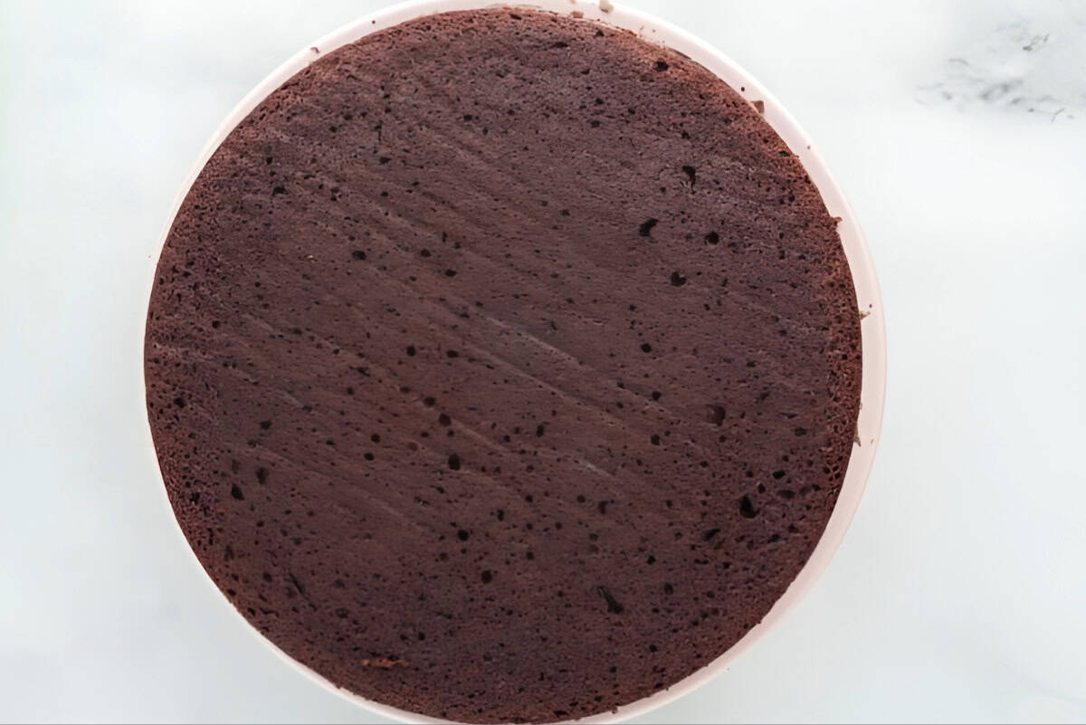 a chocolate cake layer on a cake stand.
