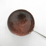 chocolate sauce in a spoon on a white background.