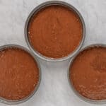 a group of round metal containers with brown liquid in them.