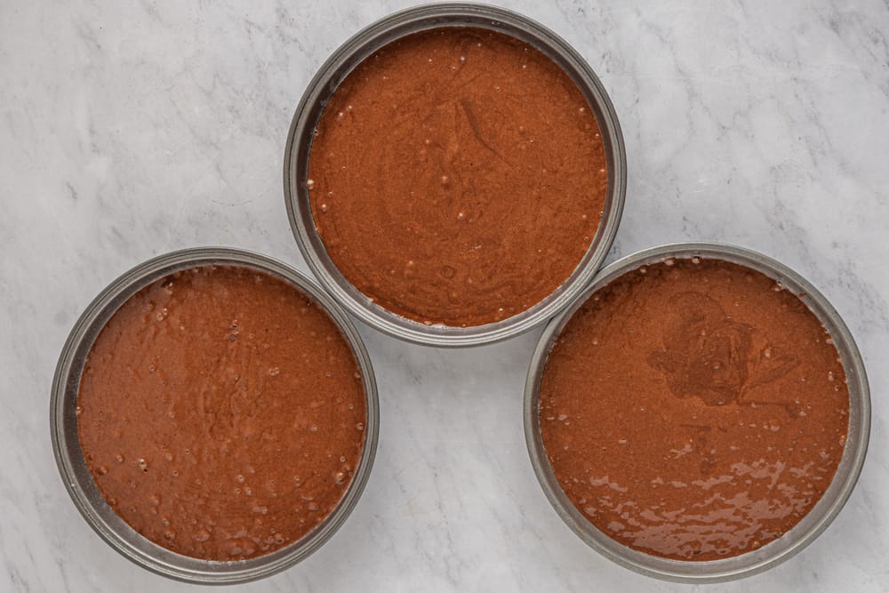 a group of round metal containers with brown liquid in them.