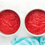 2 round red velvet cake layers in baking pans.
