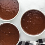 chocolate fudge cake batter divided between 3 round baking pans.