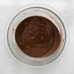 Chocolate sauce in a glass bowl on a white background.