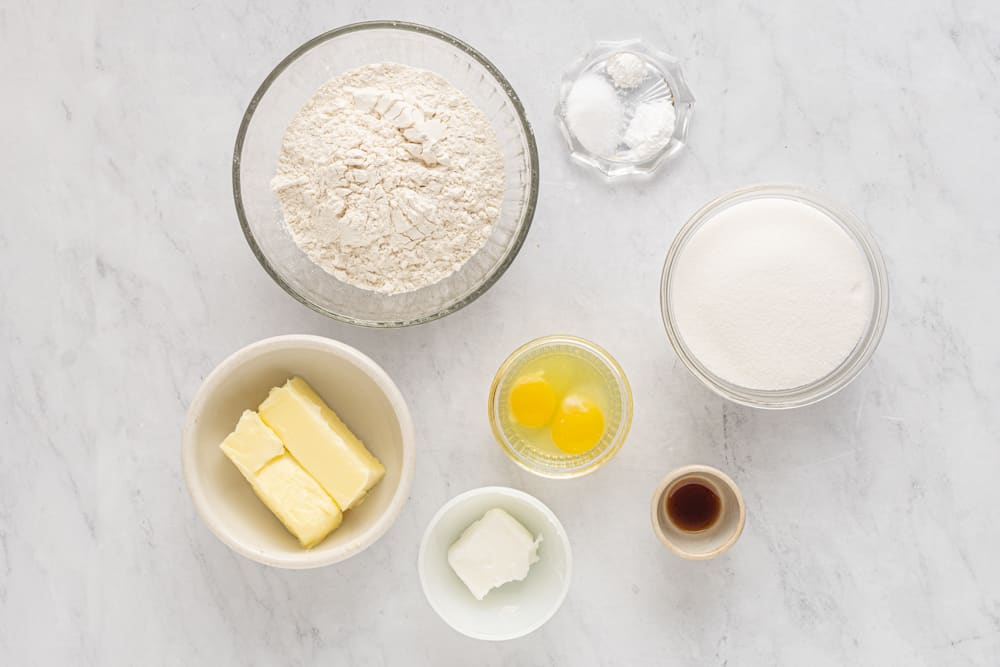 a group of bowls of flour butter eggs and butter.