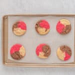 a tray of cookies with red and pink icing on it.