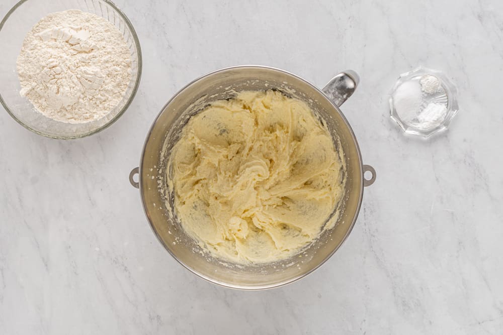 a bowl of flour and a bowl of dough.