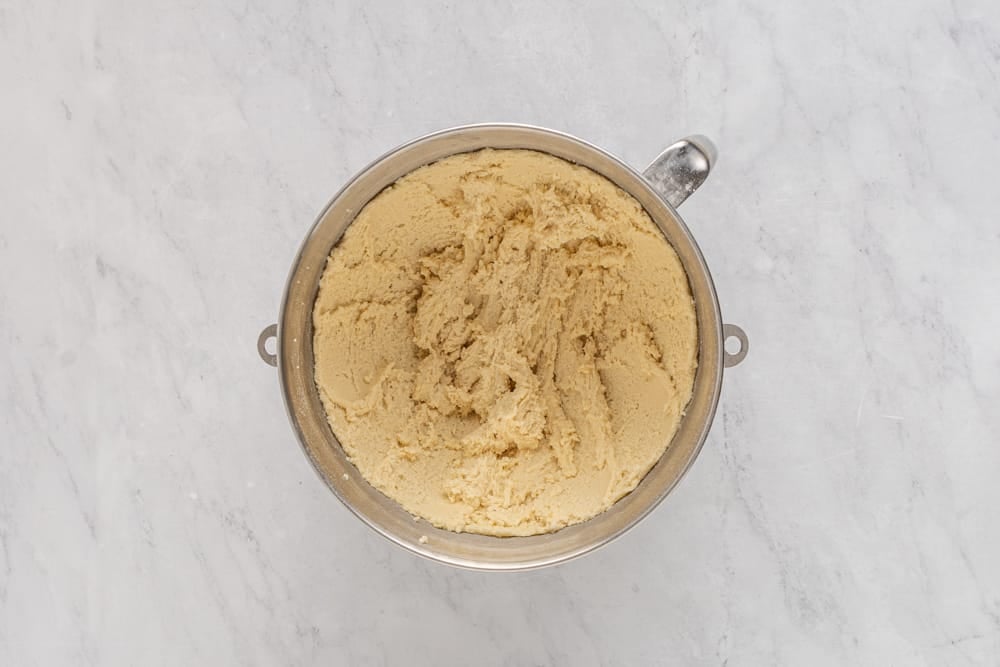 a bowl of mashed bananas on a marble countertop.