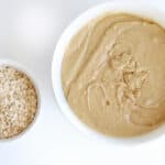 overhead view of a large bowl of cookie batter, next to a small bowl of oats