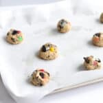 cookie dough balls arranged on a parchment lined baking tray