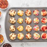 mini pancake muffins in a muffin tin, with bowls of toppings