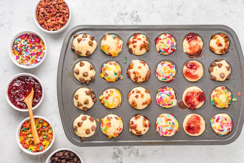 mini pancake muffins in a muffin tin, with bowls of toppings