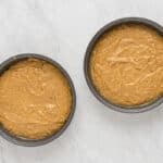 two pans with peanut butter in them on a marble table.