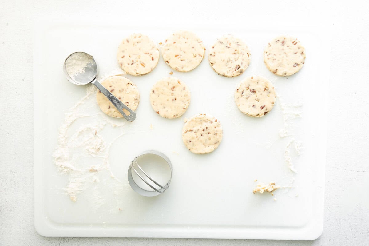 a white board with round cookies and a cookie cutter.