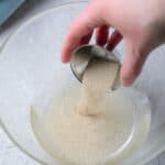 yeast poured into warm water in a glass bowl.