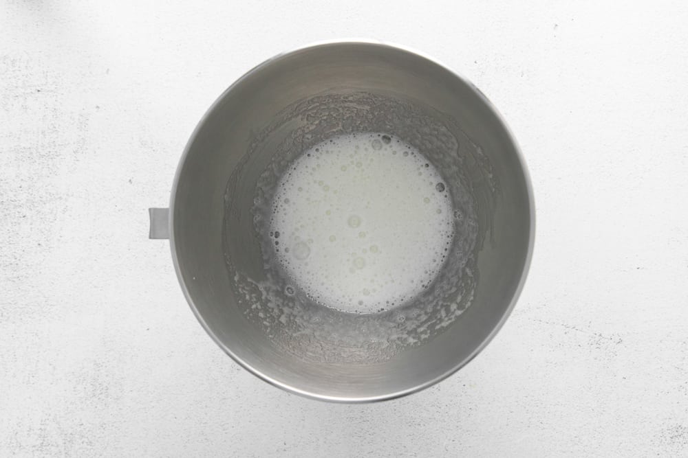 whisked sugar and egg whites in a stainless mixing bowl.