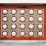 piped raspberry macaron batter on a silpat lined baking sheet.