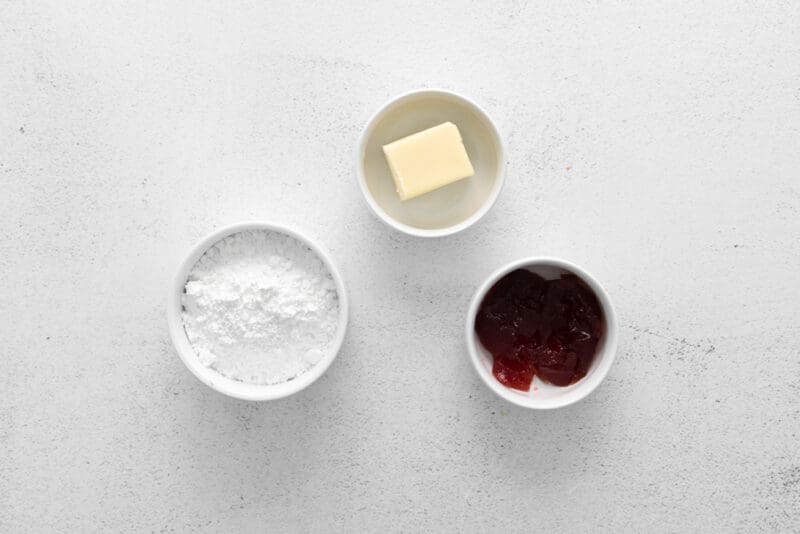 overhead view of ingredients for raspberry macaron buttercream in individual bowls.