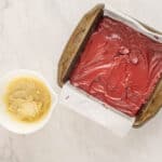 red velvet brownie batter in a square baking pan.