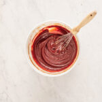 red velvet cheesecake brownie batter in a white bowl.