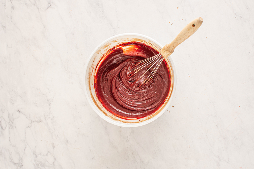 red velvet cheesecake brownie batter in a white bowl.