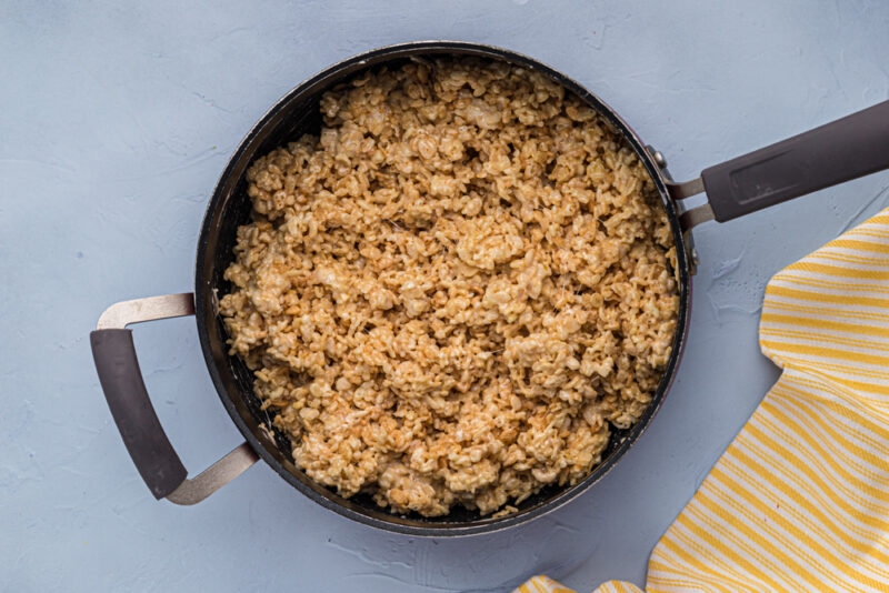 brown rice in a skillet on a blue background.