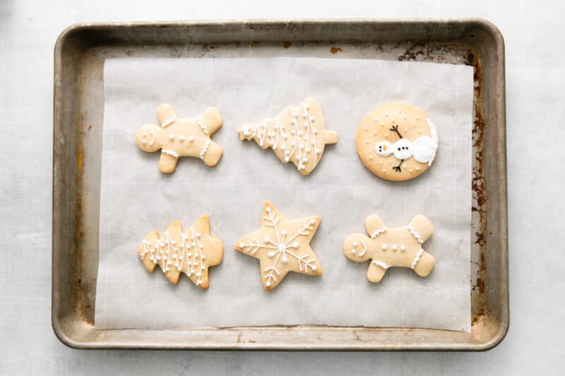iced christmas cookies on a baking sheet.