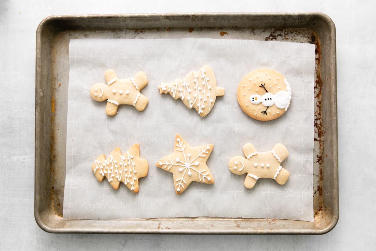 iced christmas cookies on a baking sheet.