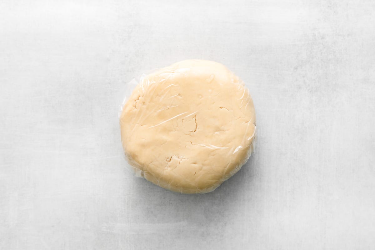 a round white dough wrapped in plastic.