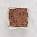 avocado brownie batter spread into a square baking pan.