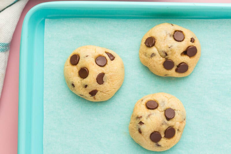 closeup of 3 rolo stuffed cookies on a baking sheet.