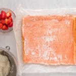 unrolled strawberry cake on parchment.