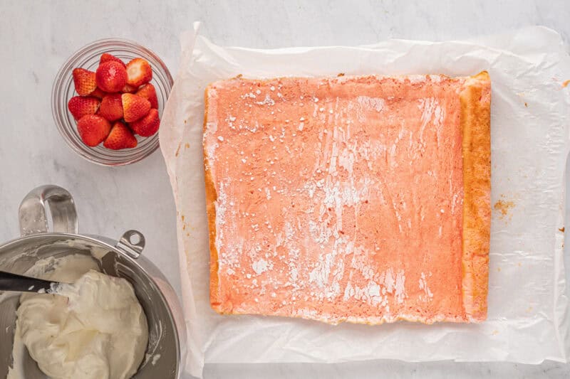 unrolled strawberry cake on parchment.