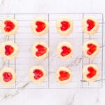 12 heart thumbprint cookies on a wire cooling rack.