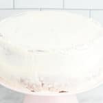 crumb-coated lemon cake on a pink cake stand.