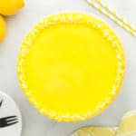 frosted lemon cake with sprinkles on a cake stand.