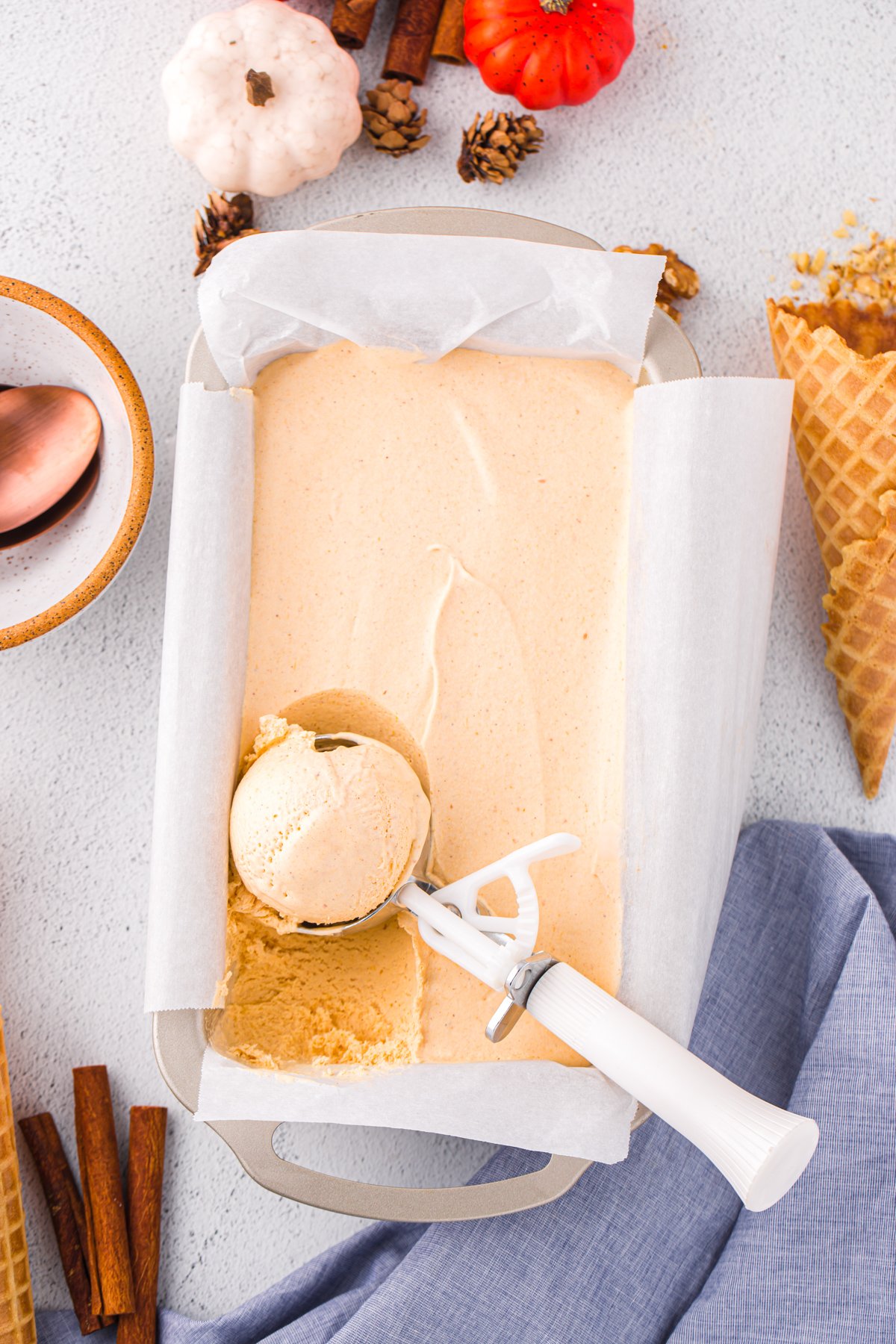 ice cream scoop scooping pumpkin ice cream out of a bread pan