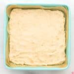 shortbread cookie crust pressed into a lined square baking pan.