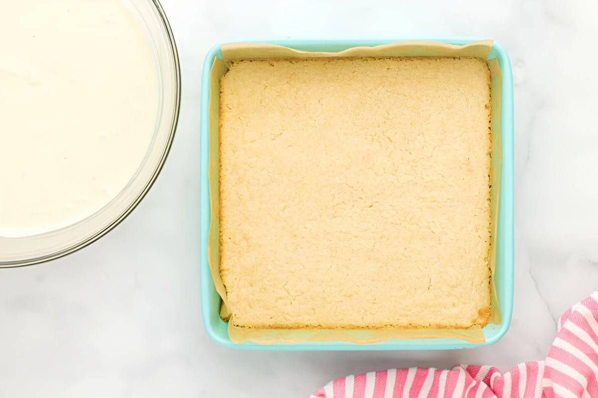 baked shortbread cookie crust in a lined square baking pan.
