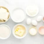 ingredients for rainbow cheesecake bars in individual bowls.