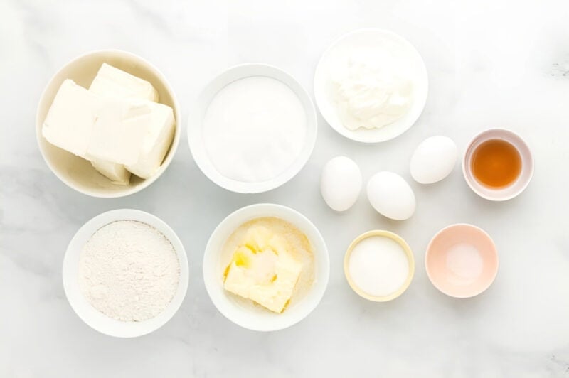 ingredients for rainbow cheesecake bars in individual bowls.