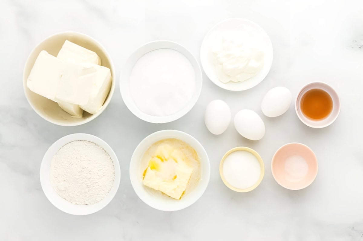 ingredients for rainbow cheesecake bars in individual bowls.